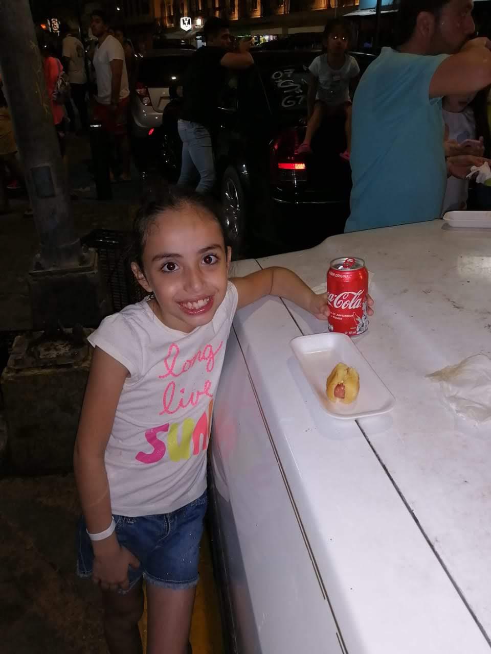 Elsa de niña disfrutando un hot dog