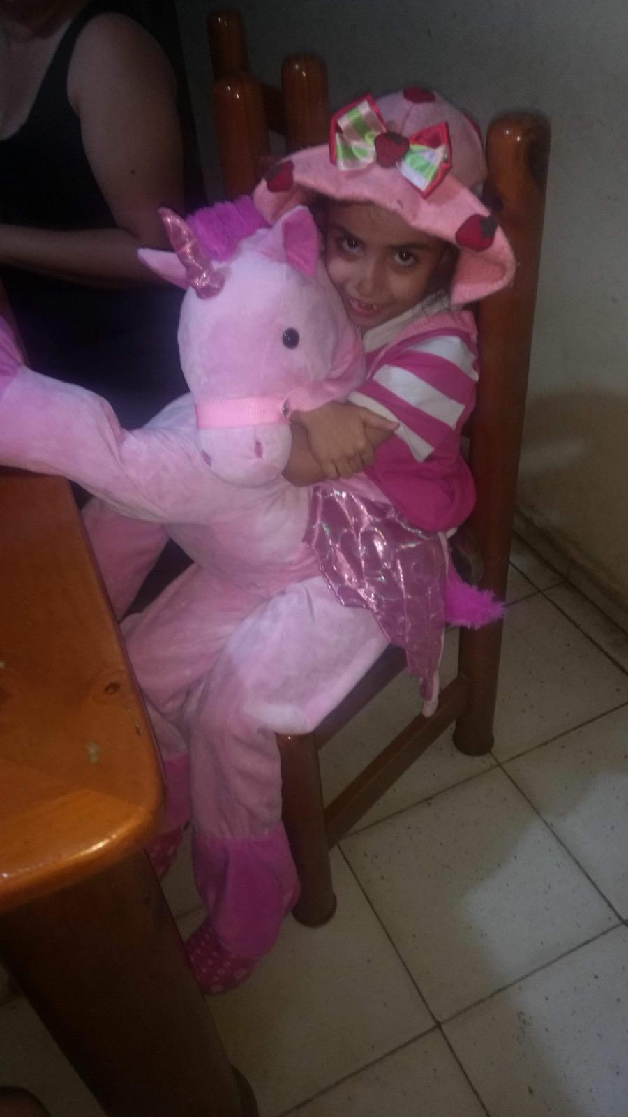 Elsa de pequeña abrazando un unicornio rosa