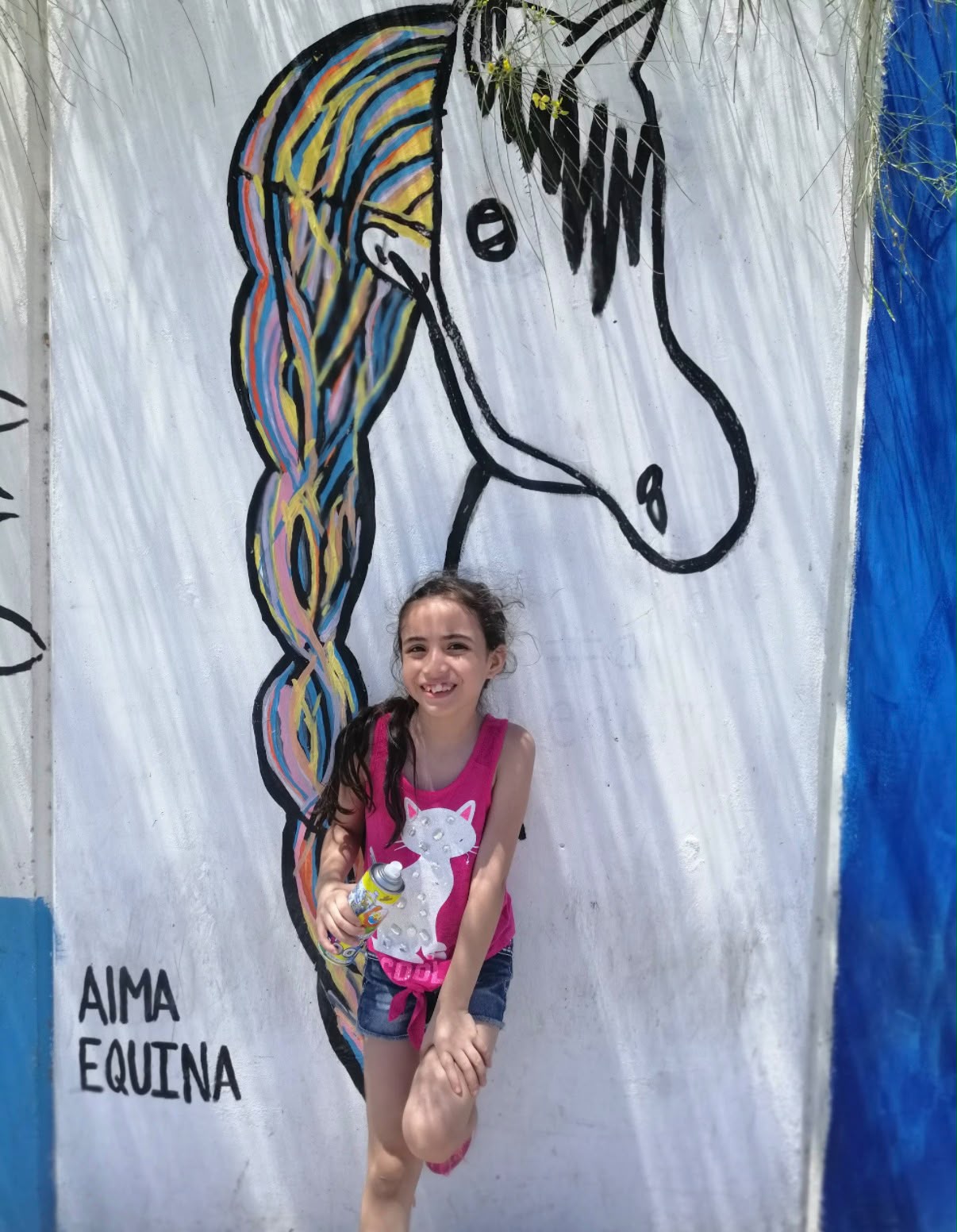 Elsa de niña frente a un mural