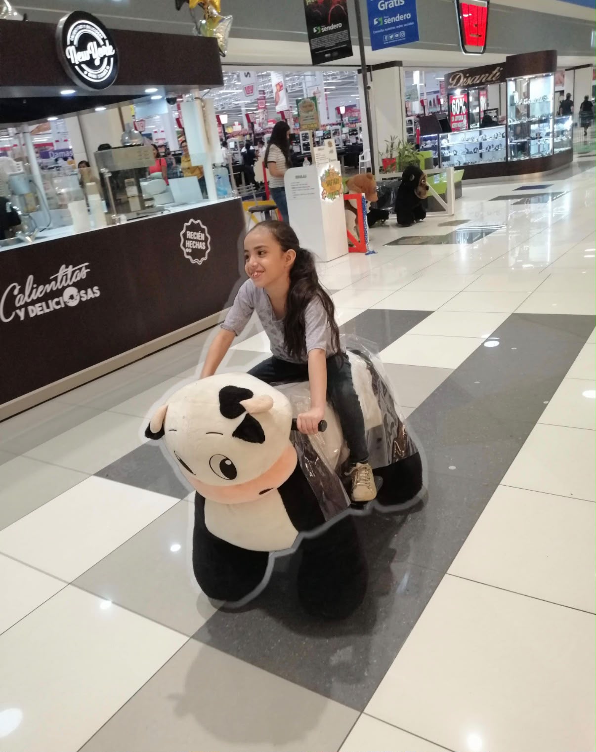 Elsa de niña sobre un juguete de vaca