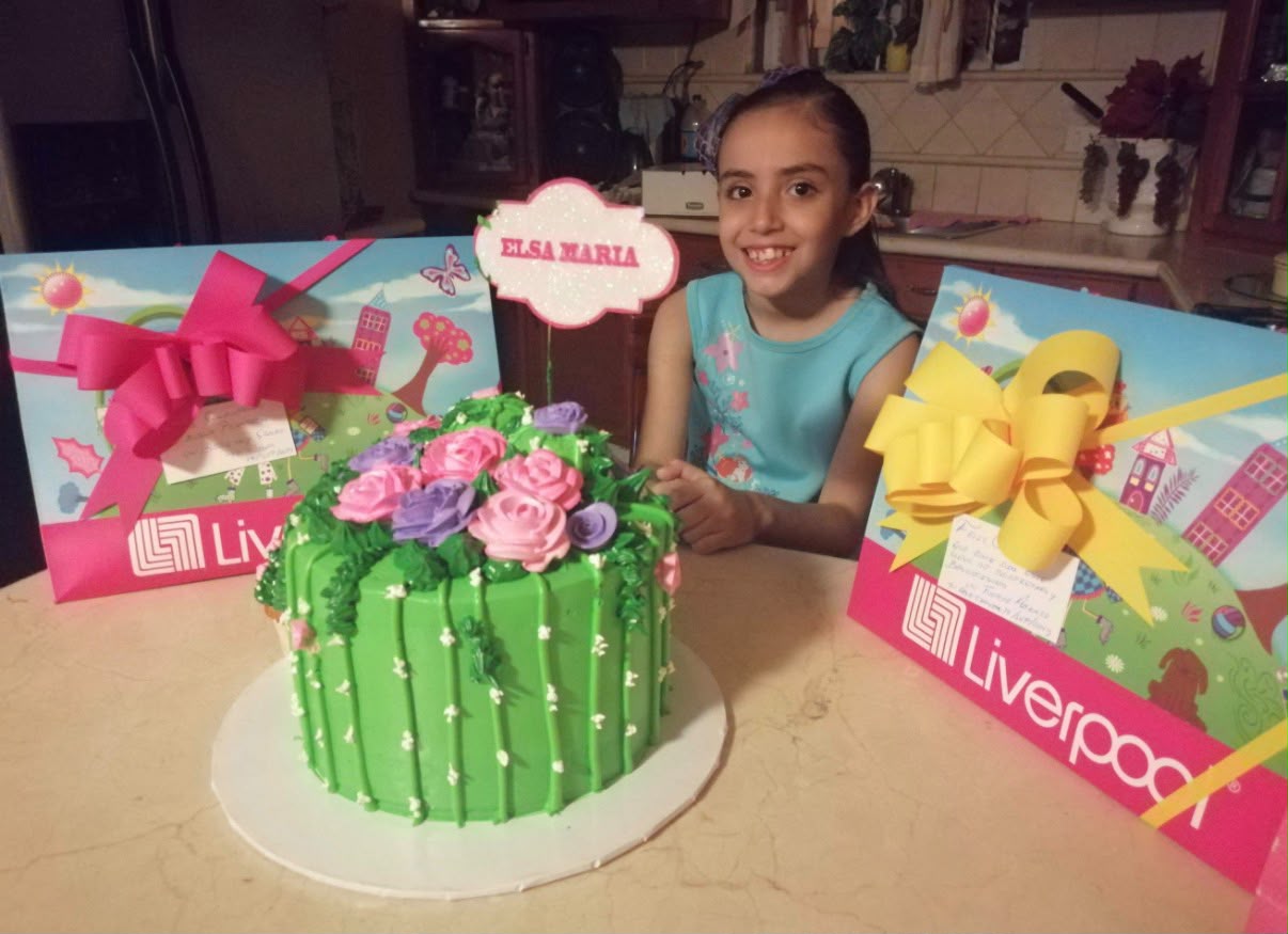 Elsa de niña junto a su pastel y regalos